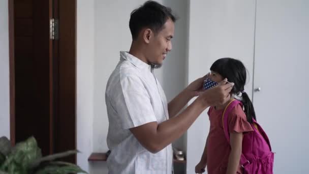 Папа надел маску на ее дочь для защиты от коронного вируса — стоковое видео