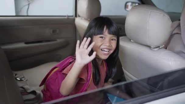 Asian primary pupil student sitting in the car and waving good bye — Stock Video