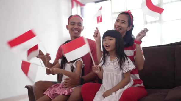 Entusiasta partidario de la familia indonesia mientras ve el partido deportivo en la televisión en casa — Vídeos de Stock