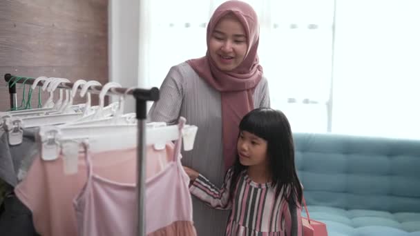 Mãe muçulmana fazendo compras com sua filha na loja de roupas boutique — Vídeo de Stock