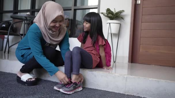 Mother help her daughter to wear a shoes in the morning — Stock Video