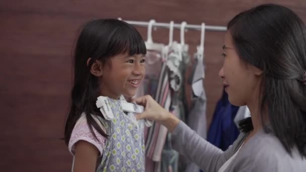 Asiático madre compras con su hija en boutique ropa tienda — Vídeos de Stock