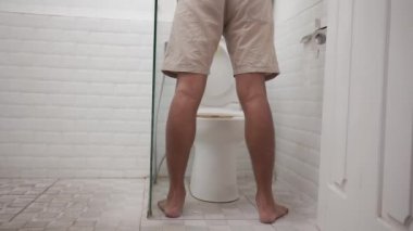 Tuvalette ayakta işeyen bir adam.