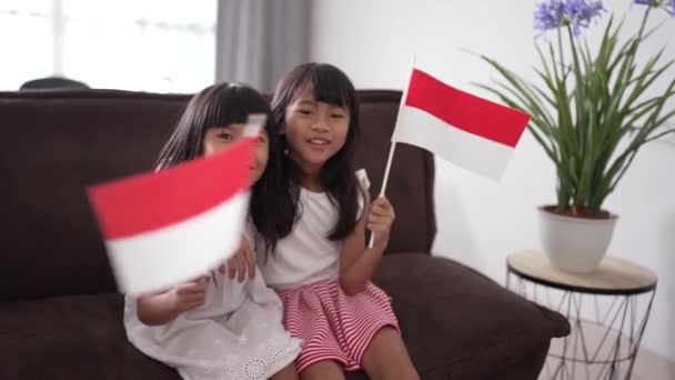 Niña indonesia sosteniendo bandera indonesia en casa — Vídeo de stock