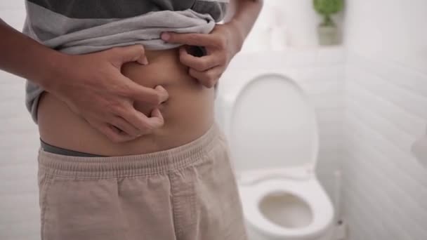 Male with stomach ache having a diarrhea in toilet and hold his belly painfully. — Stockvideo