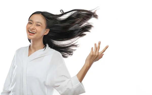 Smiling asian girl wearing a towel is standing with her long black hair blowing by wind — Fotografia de Stock