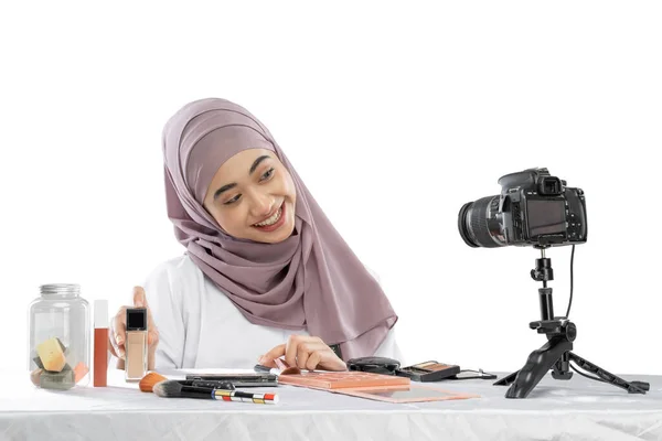Smiling asian muslim woman blogger making tutorial makeup and making videos — стоковое фото