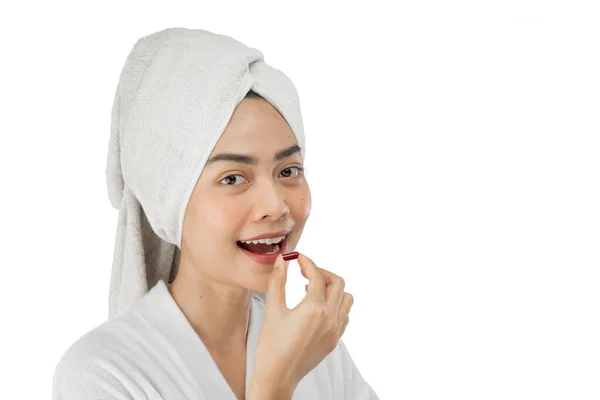 Attractive girl with bath towel on head drinking vitamin tablet with copy space — Stok fotoğraf