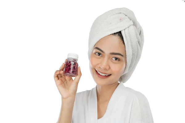 Mooie vrouw in handdoek glimlachen kijken naar camera houden fles vitaminen — Stockfoto