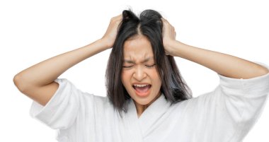 a woman wearing a towel holds her head and screams with a frustrated expression