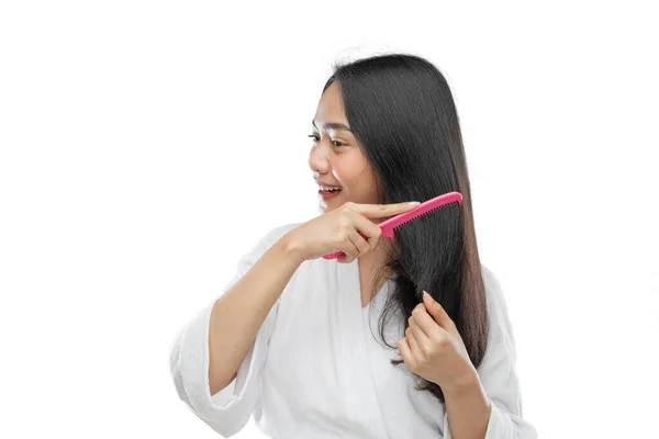 Asian woman wearing a towel combing beautiful long hair with a comb — Stok fotoğraf