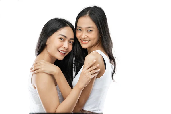 Two affectionate asian woman in a close embrace while smiling — Stockfoto