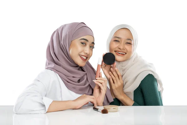 Two happy friendly veiled girl vloggers holding makeup cosmetics making video vlog — Stockfoto