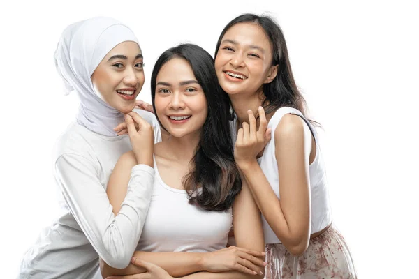 Drie gelukkig schattig vrouwen in witte kleren glimlachen terwijl het kijken naar de camera — Stockfoto