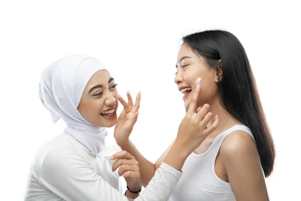 Geluk van de beste vriend lachen bij het aanbrengen van gezichtscrème met de vinger handen — Stockfoto
