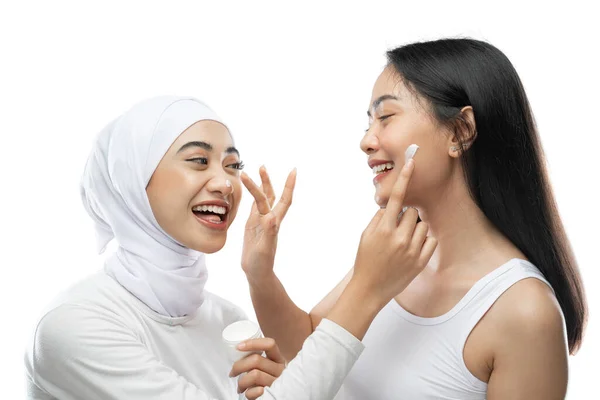 Excited asian bestfriend applying face cream with finger hands — Stock Photo, Image