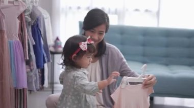 Güzel Asyalı anne kızını kıyafet almaya götürüyor.