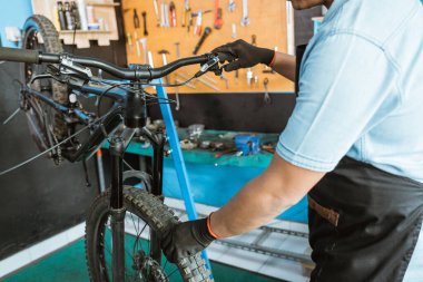 mechanical hands with gloves try the brake lever and hold the wheel to find out if the brakes are gripped