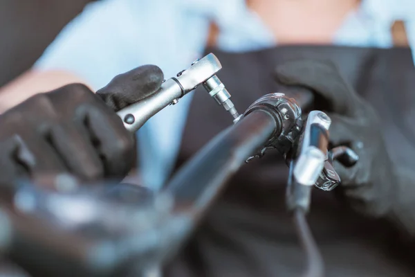 Close up of the hands of a mechanic wearing gloves using a shock wrench — Fotografia de Stock