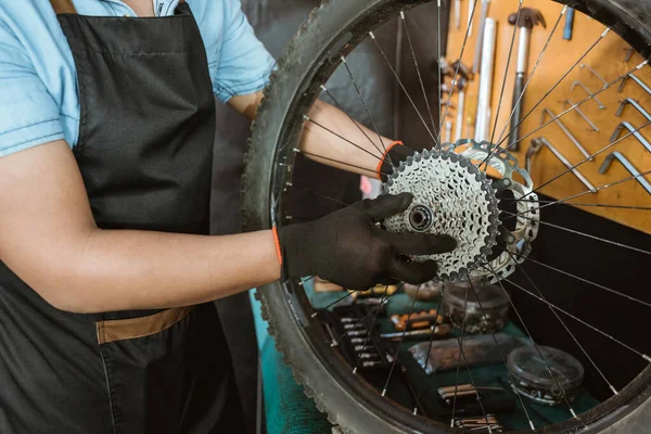 Hands of a mechanic wearing gloves installing a freewheel — Stock fotografie