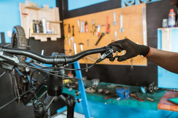 Bicycle mechanics hand with gloves on trying the brake lever — Stock fotografie