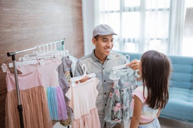father shopping with his little girl in small boutique shop