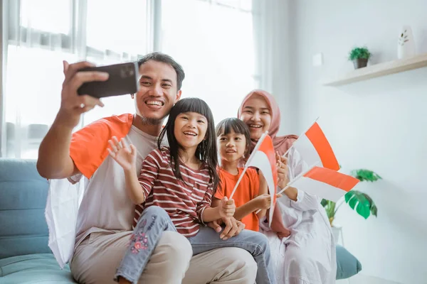 Indonesio musulmán asiático familia hacer selfie y video llamada usando su teléfono en casa — Foto de Stock