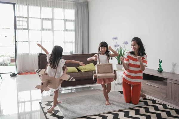 Dos hermanas jugando avión y coche hecho de caja de cartón corriendo alrededor de la casa — Foto de Stock