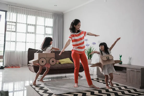 Chica jugando con cartón juguete avión en casa con madre — Foto de Stock