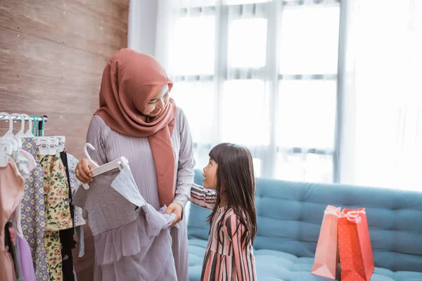 Mãe muçulmana fazendo compras com sua filha na loja de roupas boutique — Fotografia de Stock