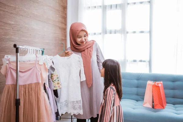 Mother muslim choosing a dress for her daughter at clothing store — Foto Stock