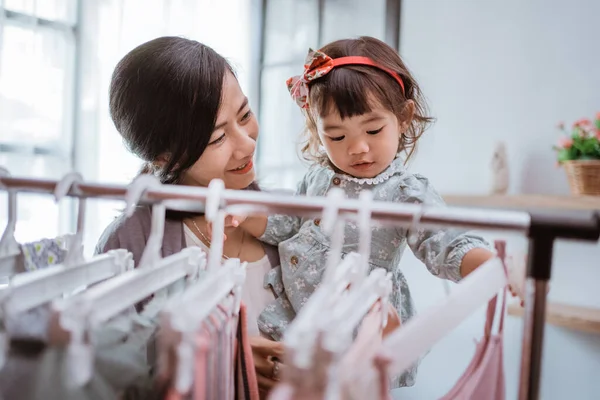 Hermosa asiático madre tomando su hija a comprar ropa —  Fotos de Stock