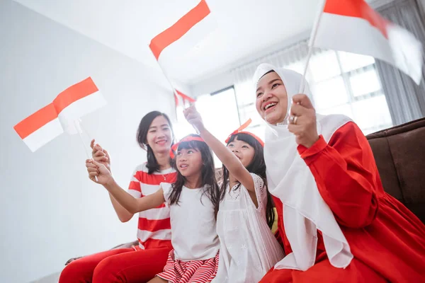 Aufgeregter indonesischer Familienangehöriger beim Zusehen eines Sportspiels im heimischen Fernsehen — Stockfoto