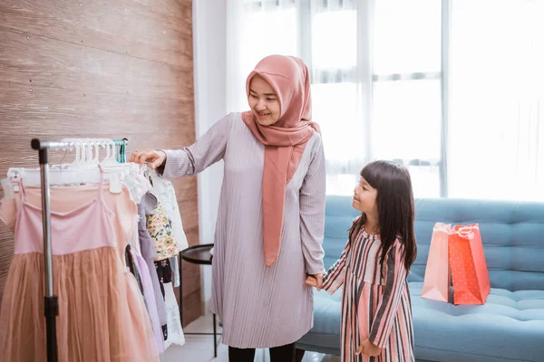 Mãe muçulmana fazendo compras com sua filha na loja de roupas boutique — Fotografia de Stock