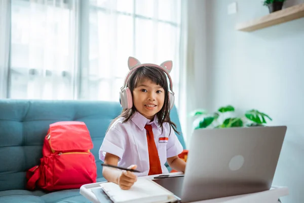 First grade school student with uniform during online class study with teacher at home — Stock Photo, Image