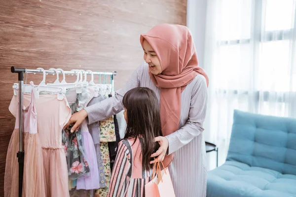 Mother muslim choosing a dress for her daughter at clothing store — Fotografia de Stock