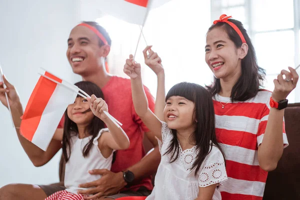 Opgewonden Indonesische familie supporter tijdens het kijken naar sport wedstrijd op televisie thuis — Stockfoto