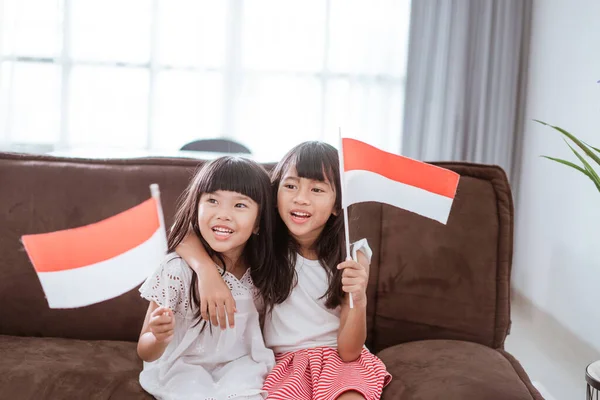 Indonesian girl holding indonesian flag at home — Zdjęcie stockowe