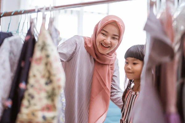 Мусульманская мать ходит с дочерью за покупками в магазин одежды — стоковое фото