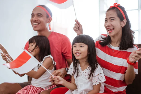 Excited indonesian family supporter while watching sport match at television at home — Zdjęcie stockowe
