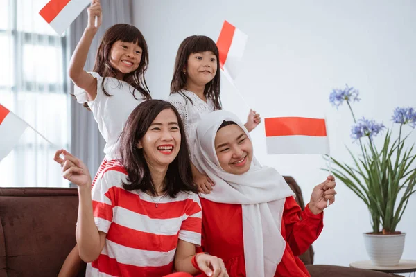Pendukung keluarga indonesia yang bersemangat saat menonton pertandingan olahraga di televisi di rumah — Stok Foto