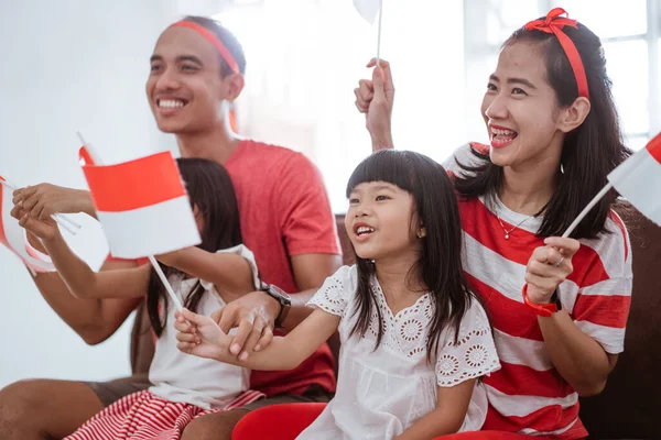 Aufgeregter indonesischer Familienangehöriger beim Zusehen eines Sportspiels im heimischen Fernsehen — Stockfoto