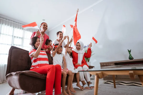 Pendukung keluarga indonesia yang bersemangat saat menonton pertandingan olahraga di televisi di rumah — Stok Foto