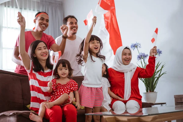 Opgewonden Indonesische familie supporter tijdens het kijken naar sport wedstrijd op televisie thuis — Stockfoto