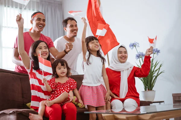 Pendukung keluarga indonesia yang bersemangat saat menonton pertandingan olahraga di televisi di rumah — Stok Foto