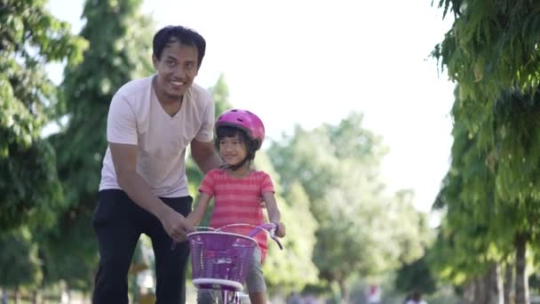 Πατέρας διδασκαλία κόρη να οδηγούν ποδήλατο στο πάρκο — Αρχείο Βίντεο