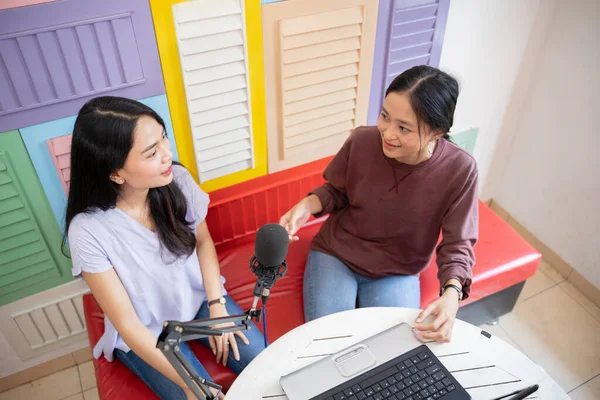Top view of two women talking using microphones during podcast — Stockfoto