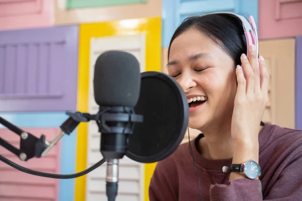 Close up of a girl wearing headphones in front of a microphone — Φωτογραφία Αρχείου