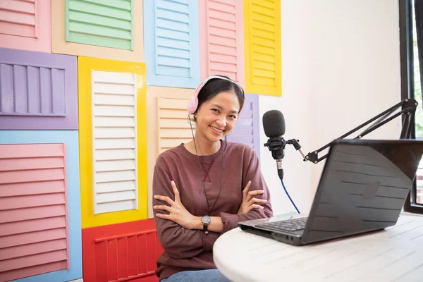 Asyalı bir kız mikrofonun önünde gülümseyerek çapraz ellerle video blogu kaydediyor. — Stok fotoğraf