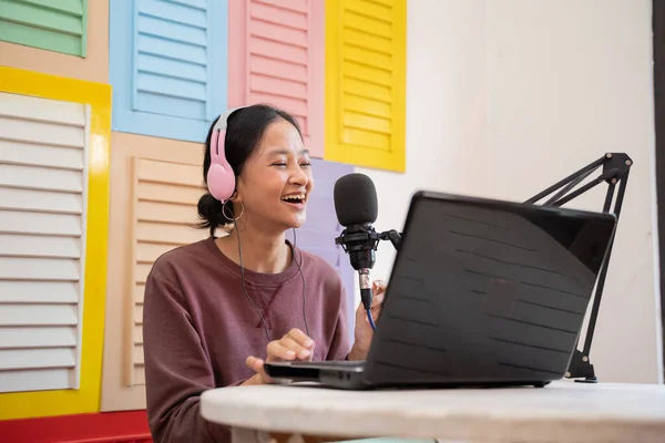 Una chica vlogger está grabando un podcast con un micrófono y una computadora portátil — Foto de Stock